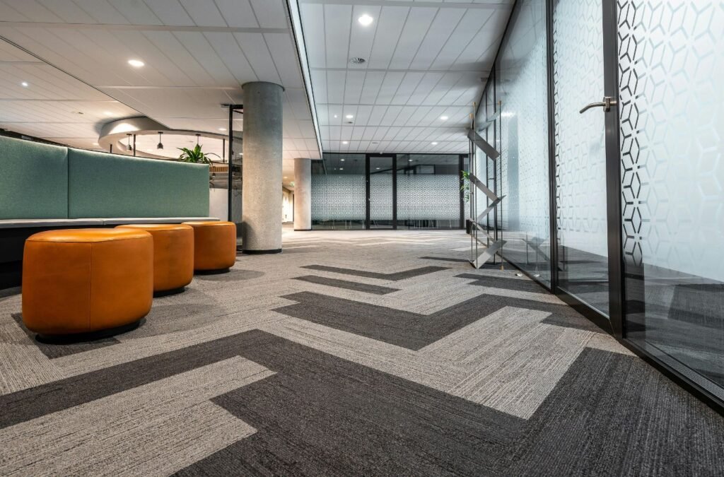 Skilled office cleaner inspecting high-touch surfaces and floor condition in active workspace. Office Cleaning near me.